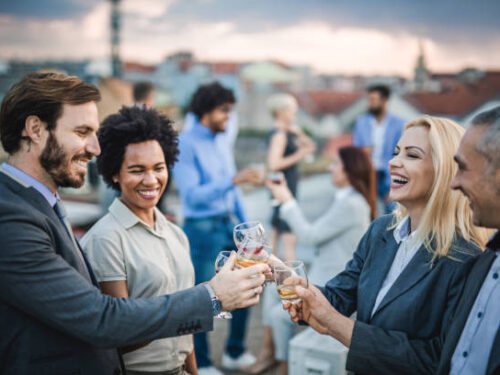Group of happy business people having fun while toasting with alcohol at the outdoor party.